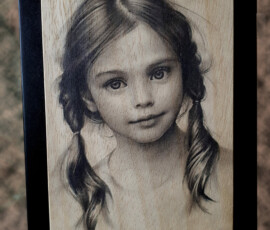 Viso di bambina inciso su legno con laser